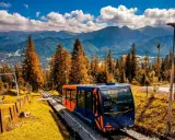 Kolejka linowo-terenowa na Gubałówkę, z widokiem na Tatry. Jesienne kolory drzew i błękitne niebo. Wejście pieszo na Gubałówkę to wspaniała przygoda.