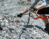 Ręce w rękawiczkach trzymają się stalowej liny na via ferrata. To część ekscytujących szlaków na Słowacji.