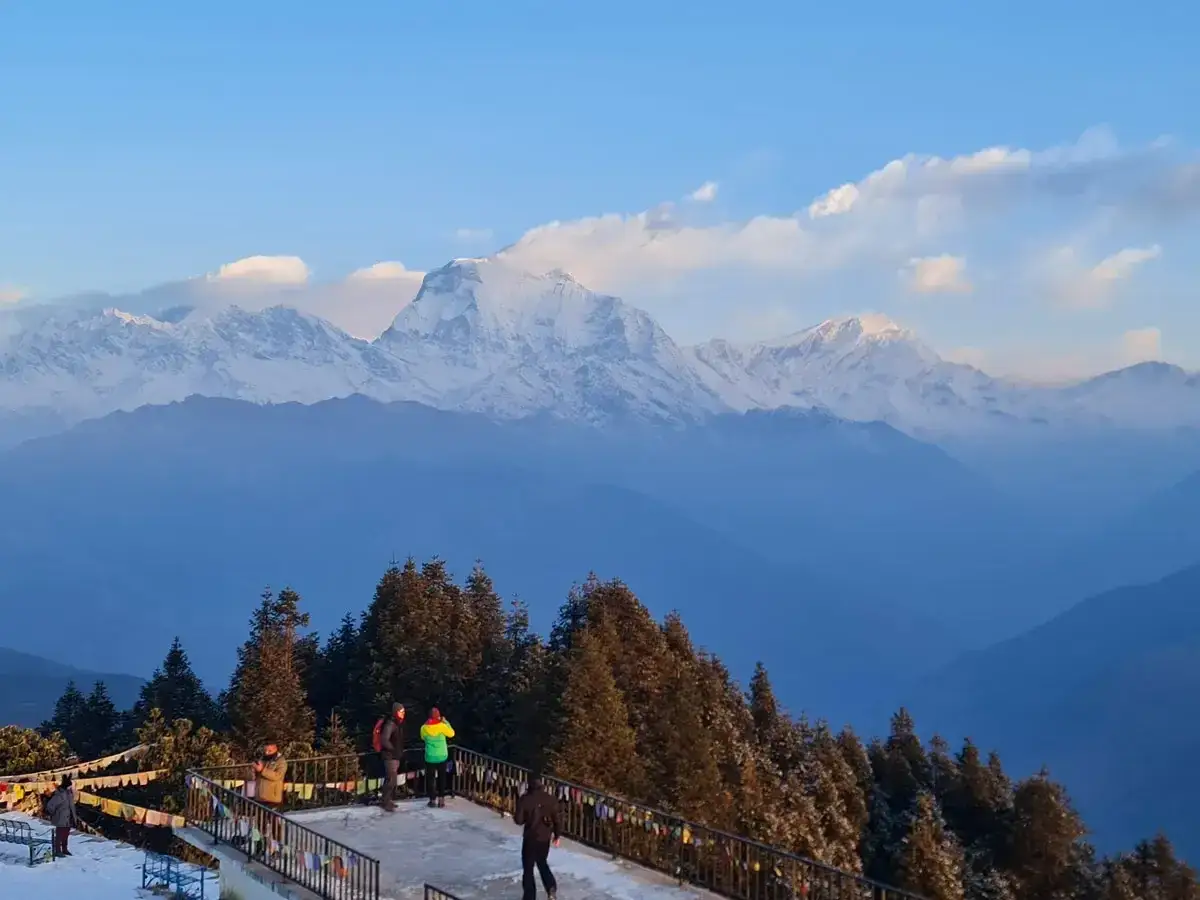 Widok na ośnieżone szczyty Himalajów podczas trekking w Nepalu. Ludzie podziwiają panoramę z tarasu widokowego.